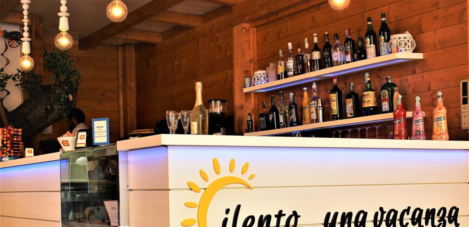 Bar accogliente con bevande, decorazioni in legno e slogan 